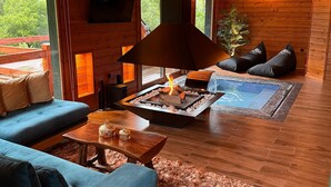 A cozy living room with a fireplace, blue sofa, and wooden flooring. - Chalet for two (Delphi)