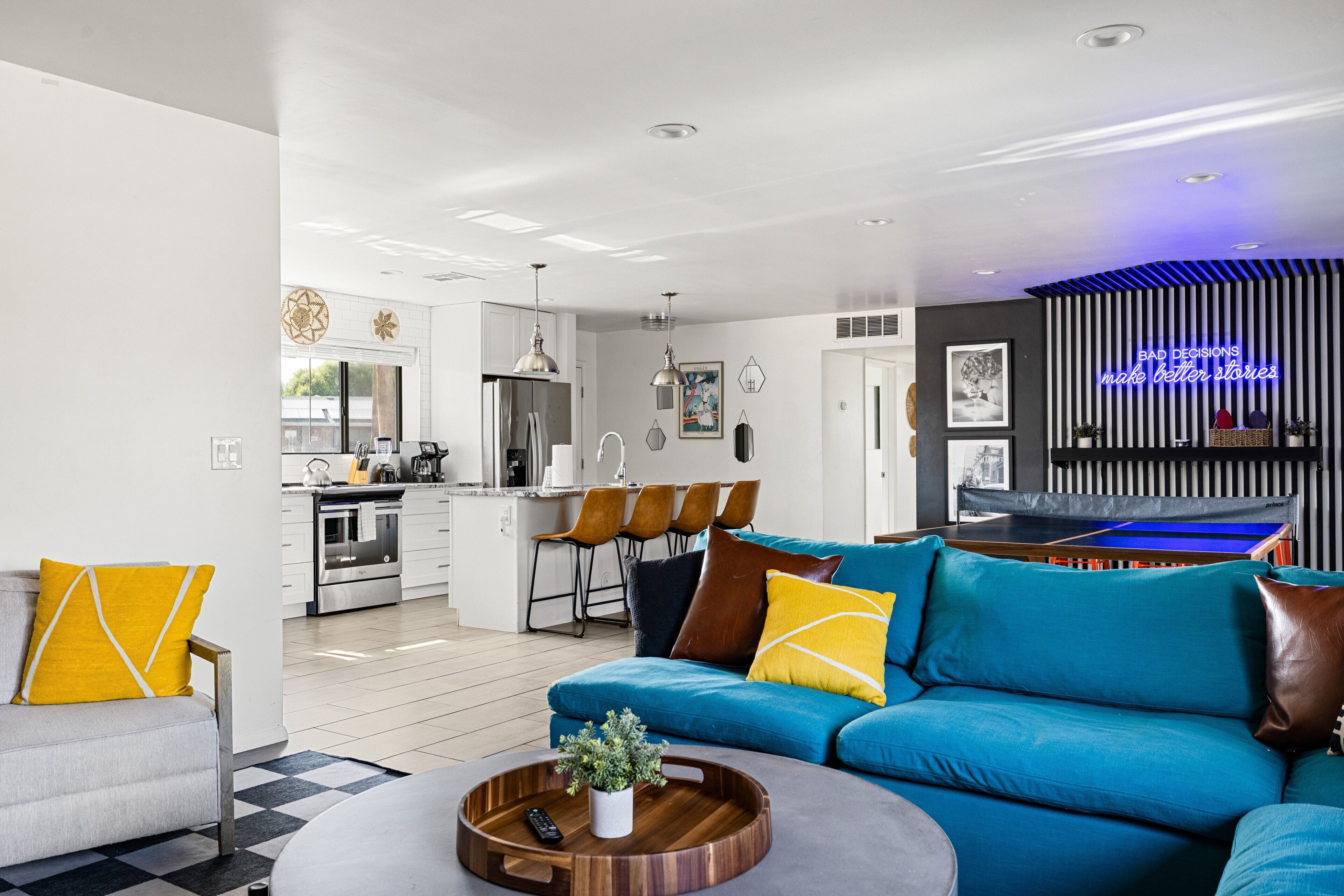 Ein modernes Wohnzimmer mit einem blauen Sofa, einem grauen Sessel und einem Couchtisch.