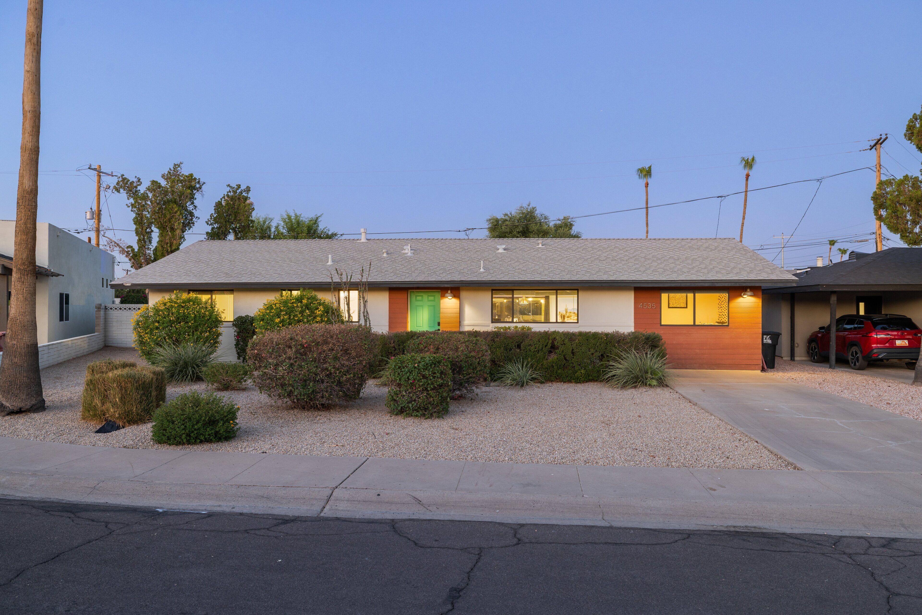 A single-story building with a garage, a well-maintained lawn, and a clear sky.