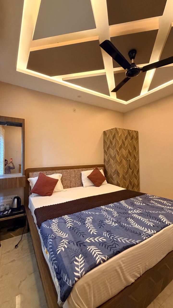 Ein modernes Hotelzimmer mit Bett, Deckenventilator und Nachttisch.