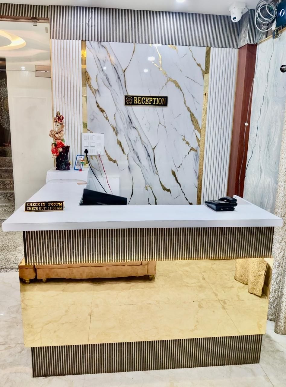 Una recepción con diseño de mármol, un letrero que indica horarios de entrada y salida, y una pequeña estatua a la izquierda.