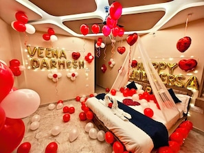 A room with a bed, balloons, and two large wall decorations with text. - Hotel The Pushpraj  (Varanasi)