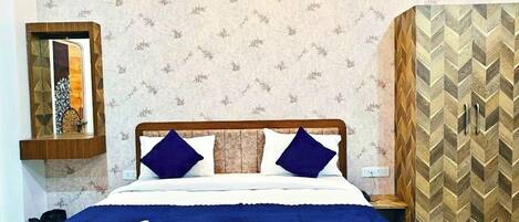 A neatly made bed with a wooden headboard, a bedside table, and a wall with a herringbone-patterned cabinet.