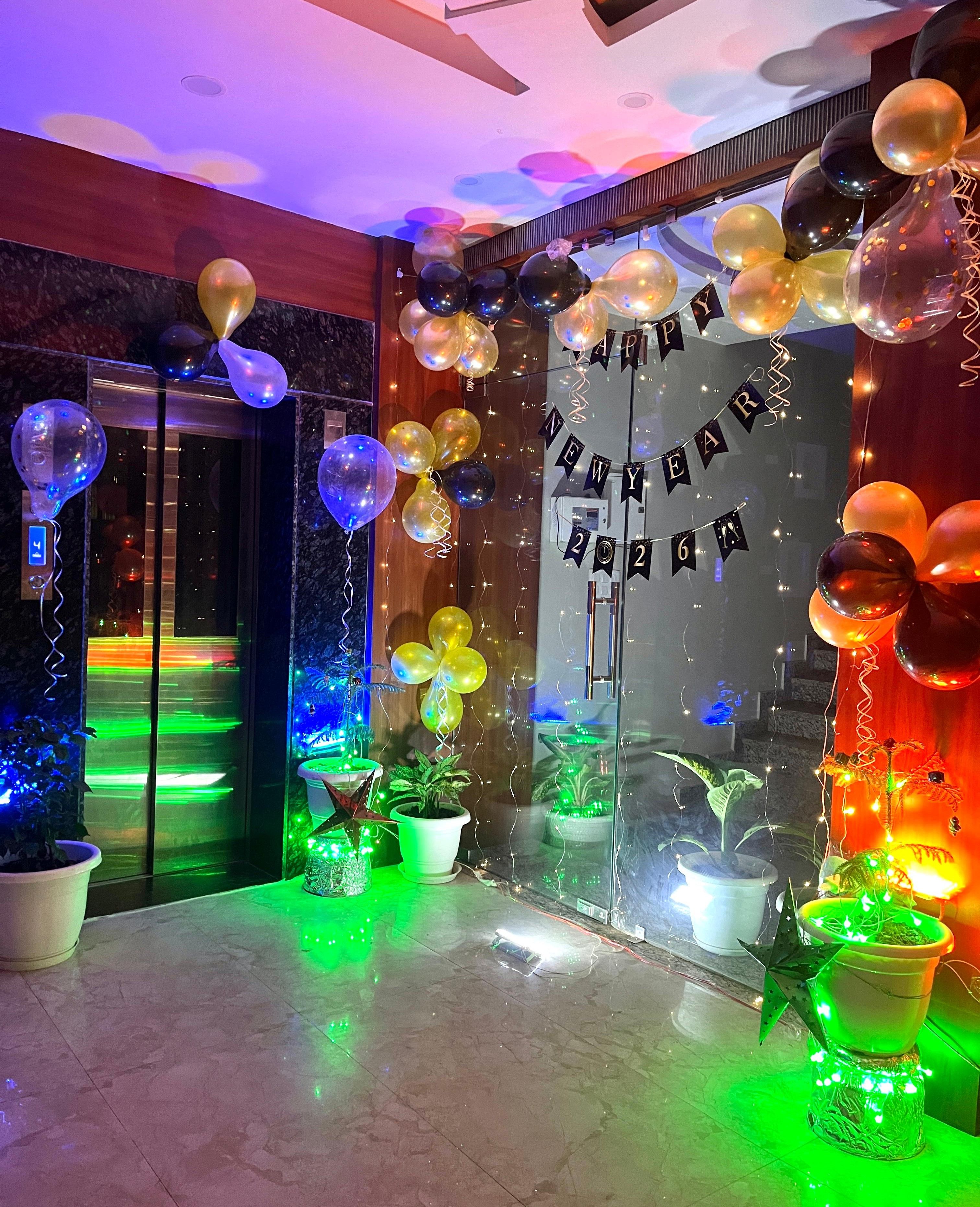 Una habitación con puerta de vidrio, globos y un cartel que dice 'Feliz Año Nuevo 2026'.