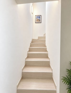 A staircase with a light wood finish, white walls, and a framed picture on the wall. - Casa Sole ,between Rome and the Sea. (Fiumicino)