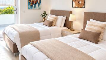 A hotel room with two beds, a painting of sailboats, an air conditioning unit, and a decorative wall piece.