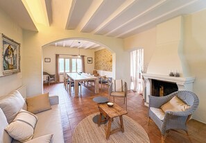 A spacious living room with a fireplace, a dining area, and a cozy seating arrangement. - Peace and elegance in a Catalan country house with a pool, 3 km from the beach. (Torroella de Montgrí)