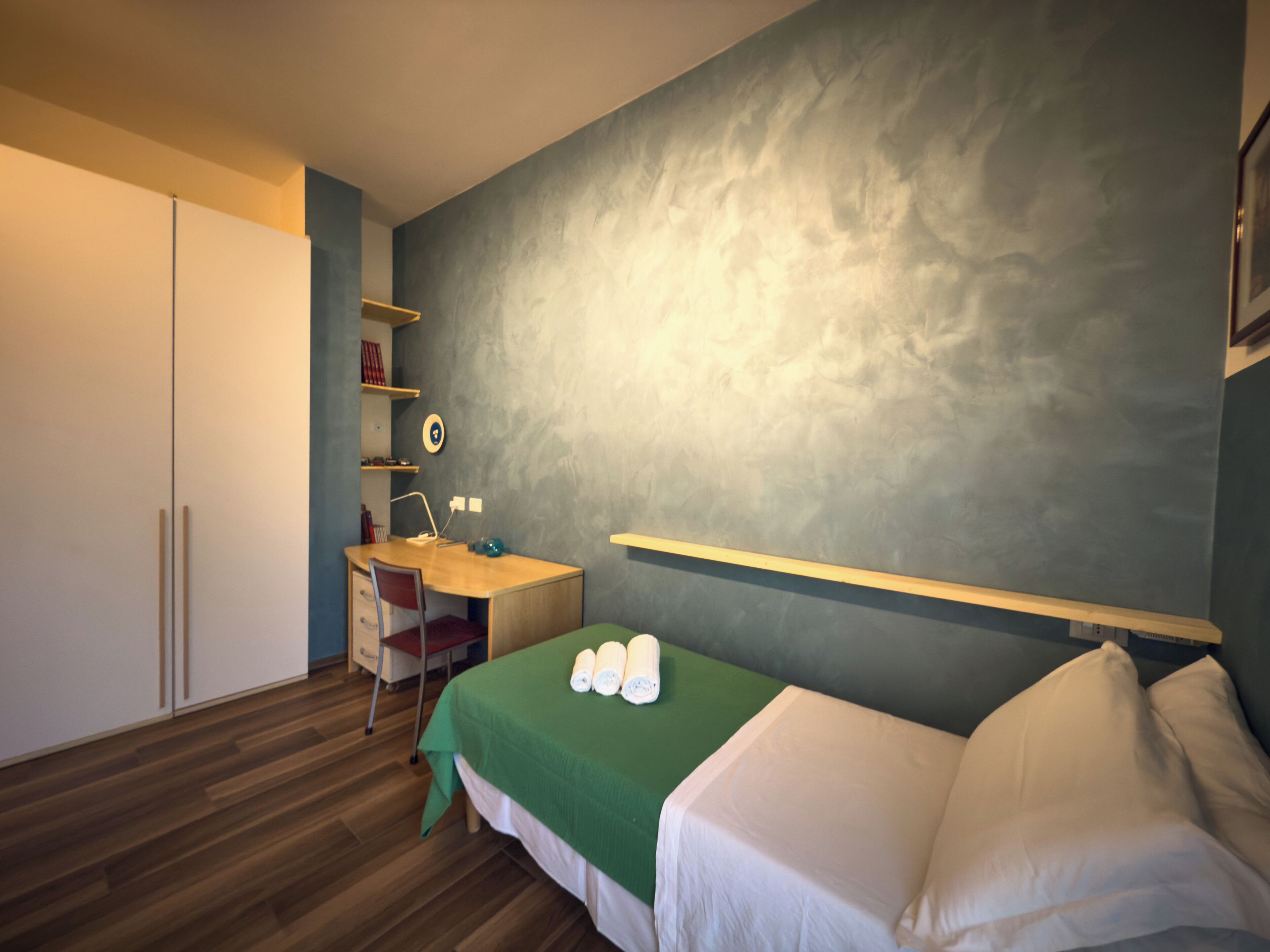 Une chambre à coucher avec un lit, un bureau et une chaise.