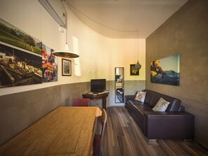 Una sala de estar moderna con una mesa de comedor, sofá y obras de arte en las paredes.