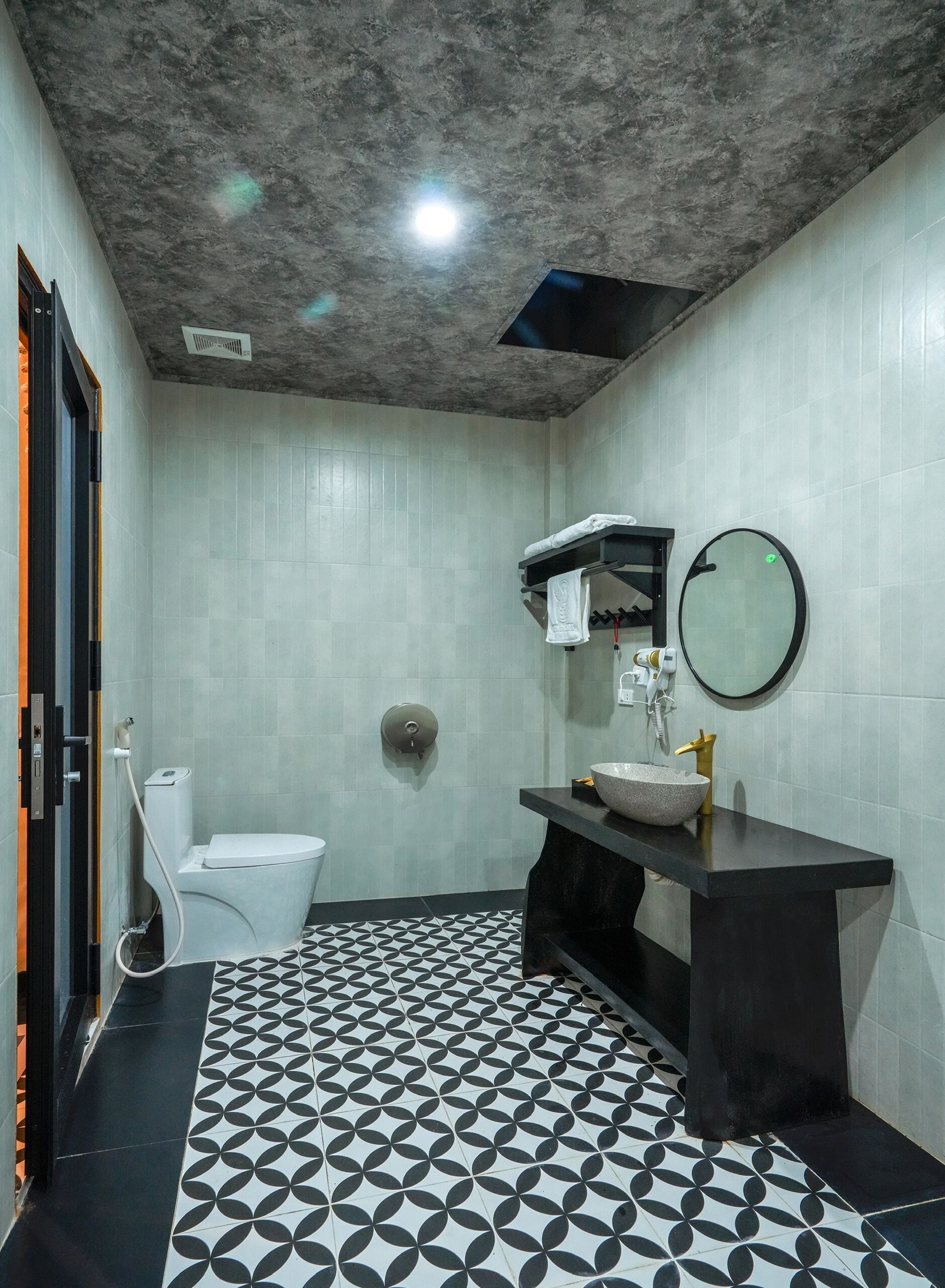 A bathroom with a toilet, sink, and mirror.