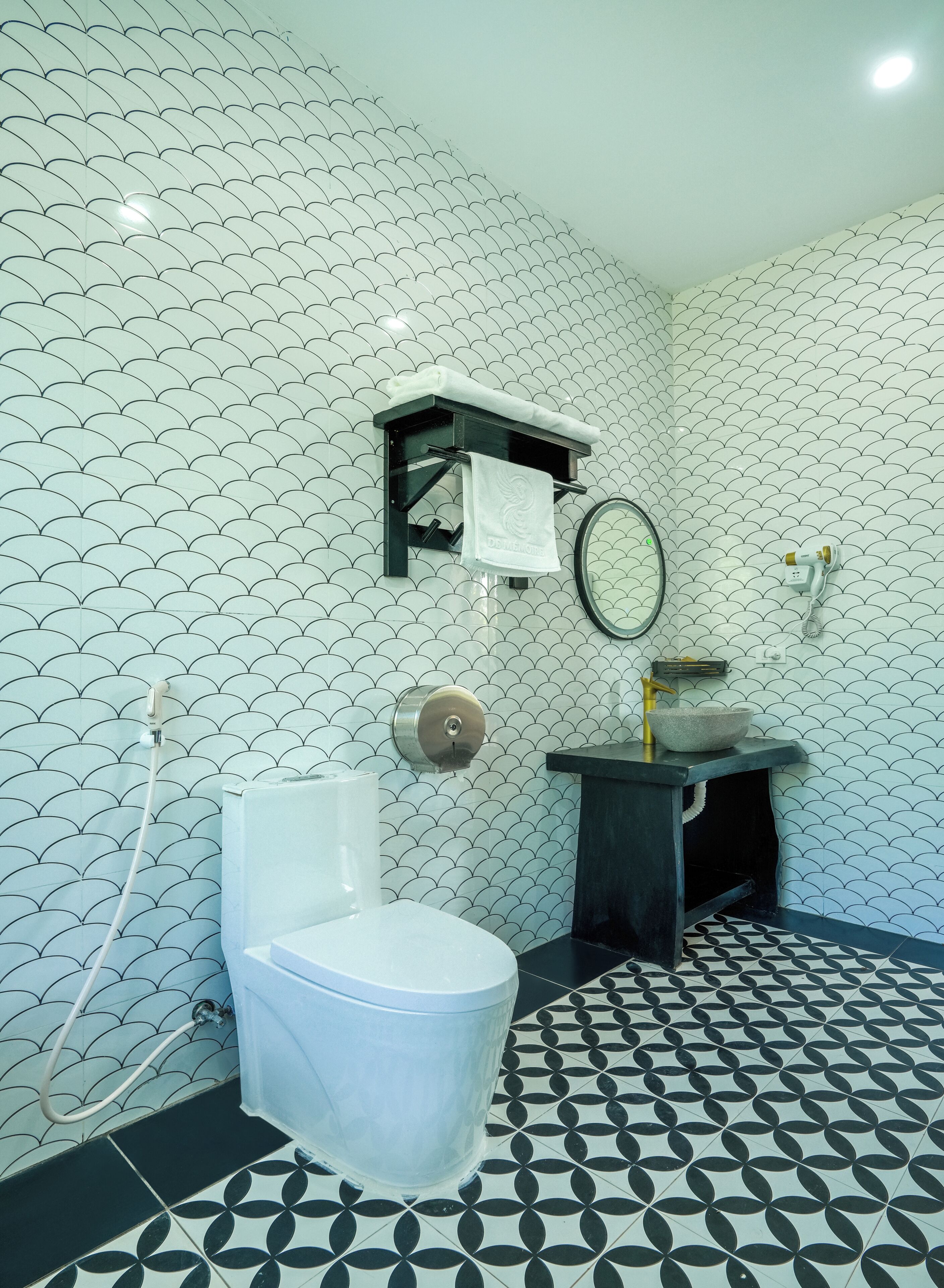 A bathroom with a toilet, a sink, a towel rack, and a shower.
