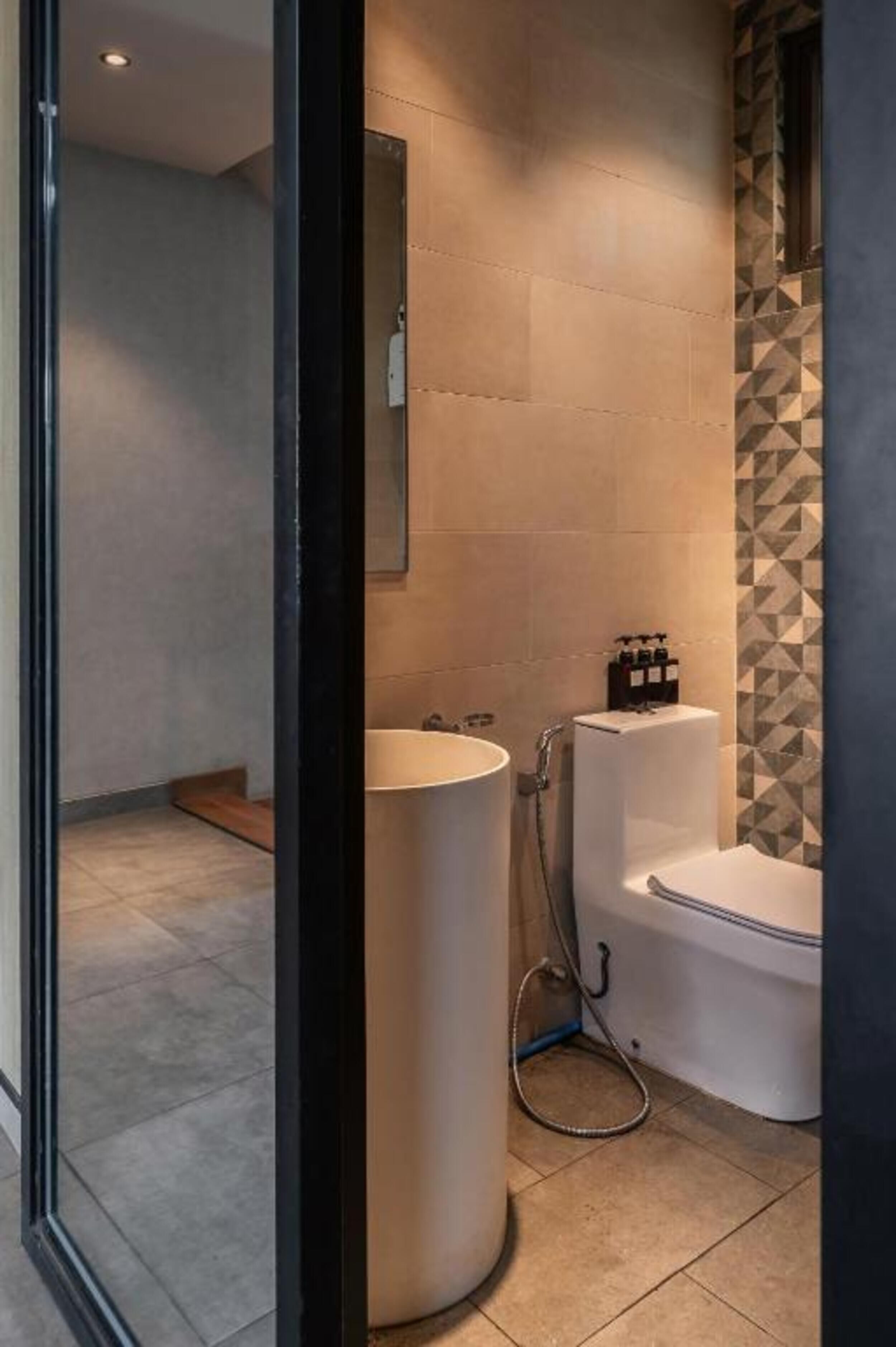A bathroom with a toilet, a sink, and a shower.