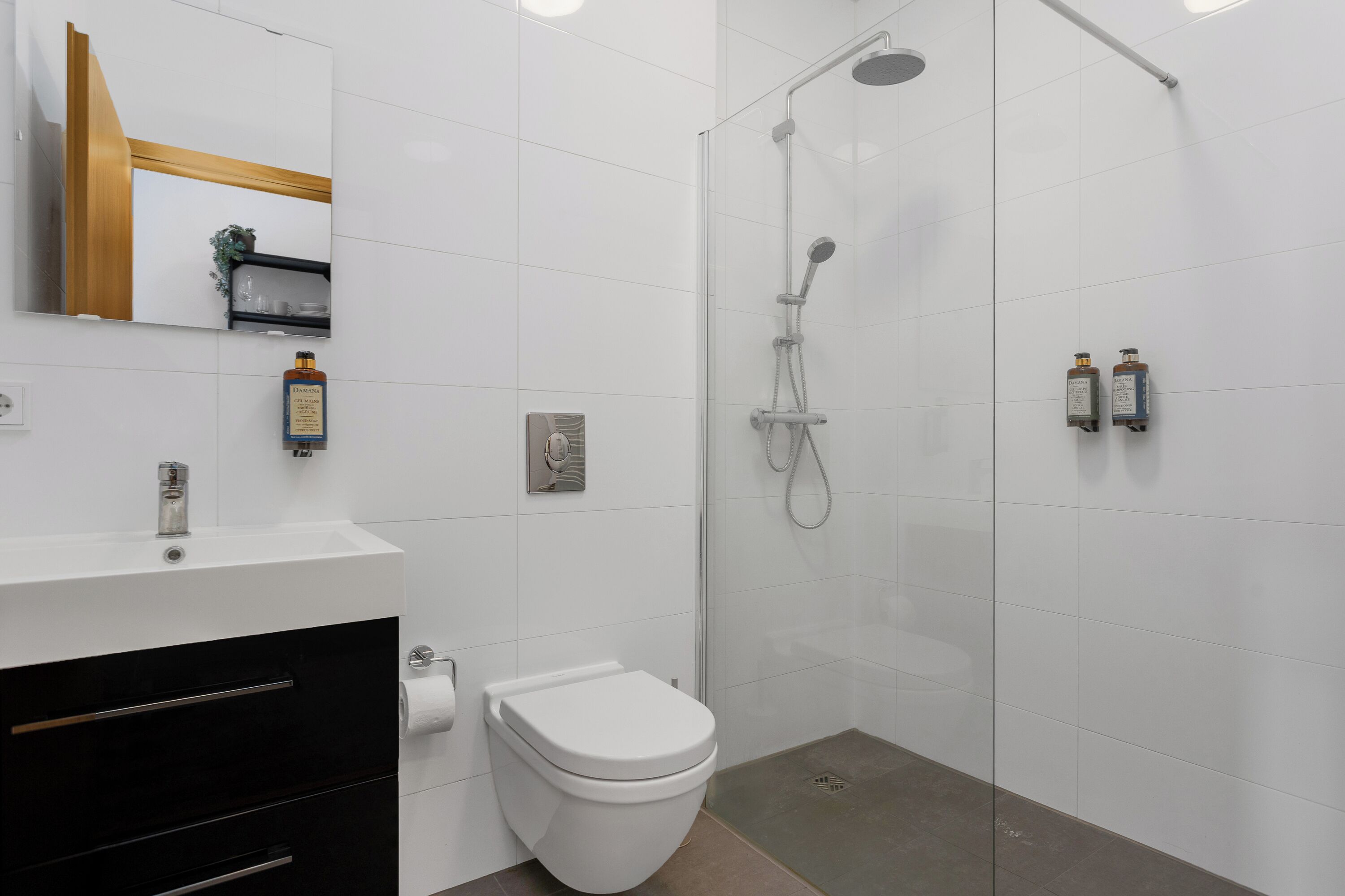 A modern bathroom with a toilet, sink, and shower.