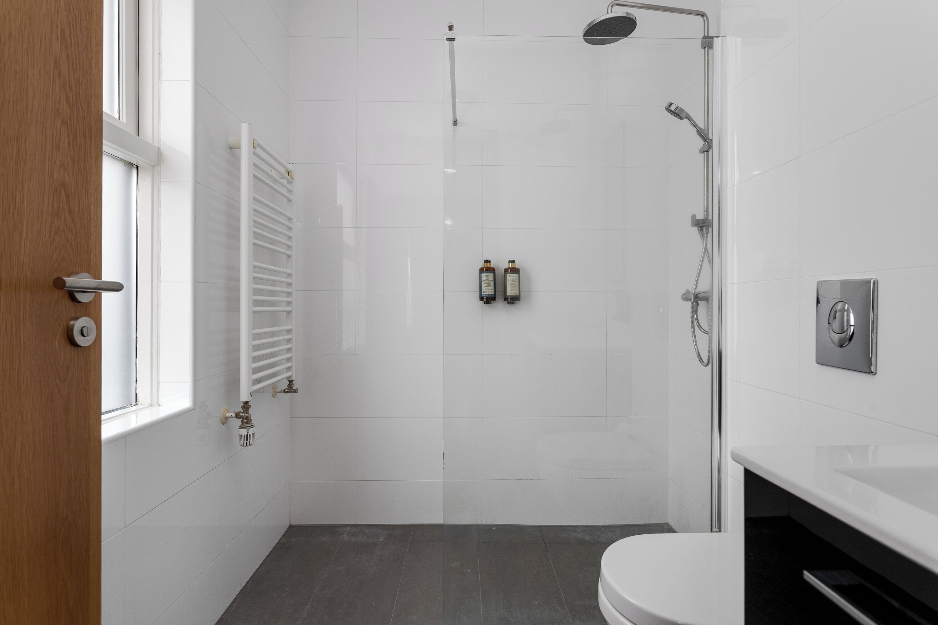 A modern bathroom with a shower, toilet, and a bathtub.
