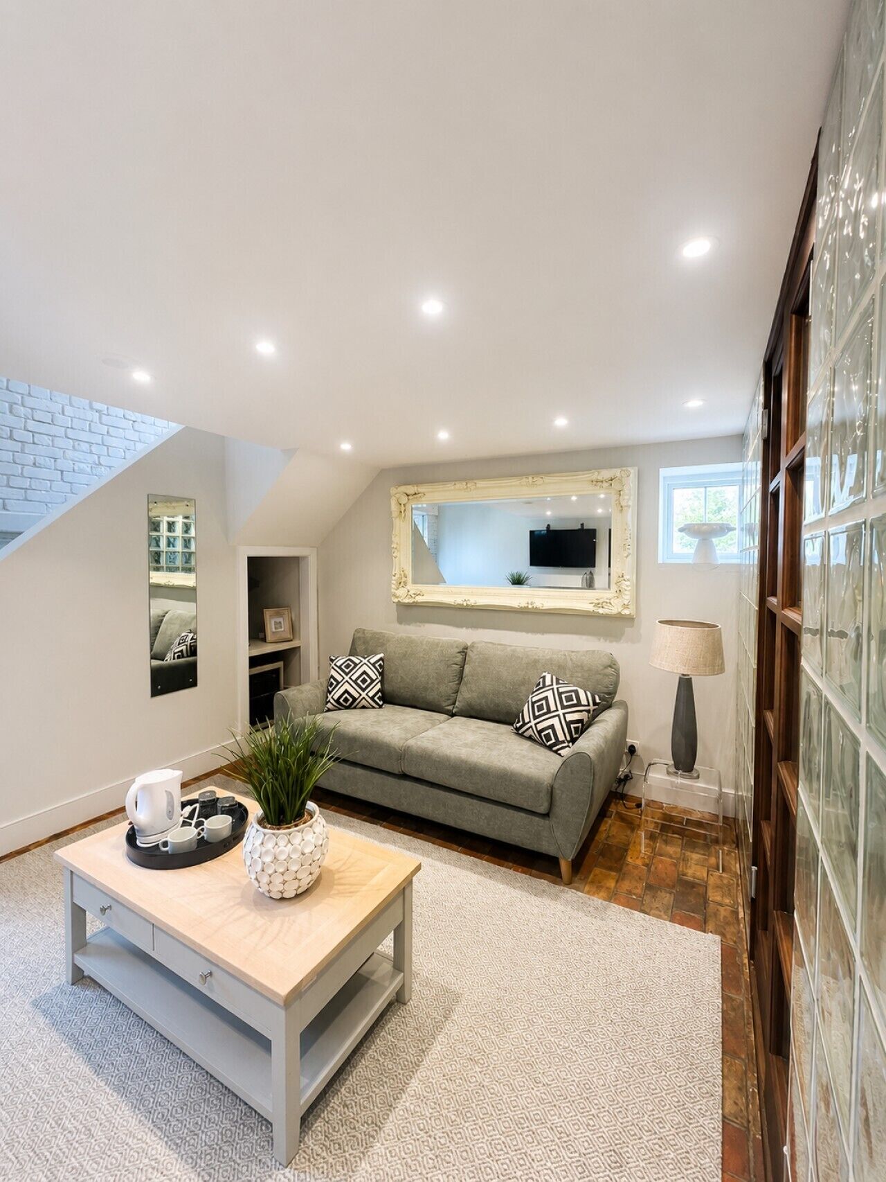 A modern living room with a sofa, coffee table, and a TV mounted on the wall.