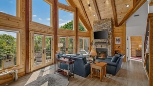 Une cabine spacieuse dotée de grandes fenêtres, d’une cheminée en pierre et d’un coin salon confortable.