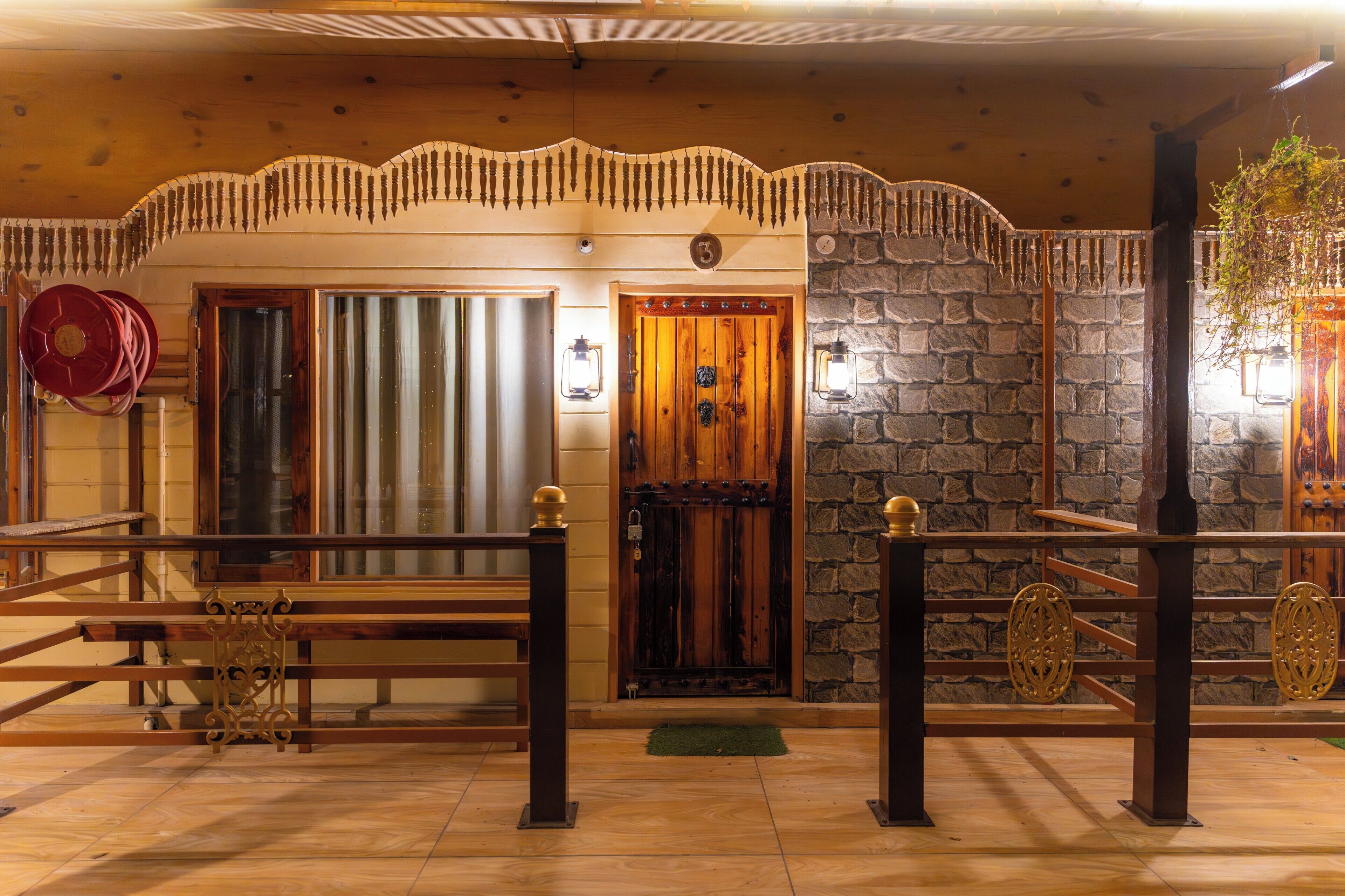 A wooden interior with a stone wall, a wooden door, and a metal gate.