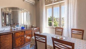 Comedor con una mesa preparada para cuatro, un espejo grande y vista al exterior.