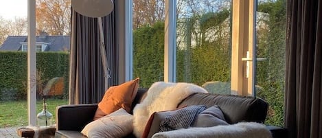 Una sala de estar moderna con un sofá, una mesita, una lámpara y una planta en maceta.