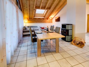 A dining area with a wooden table, chairs, a sofa, and a television. - Patricia self-check-in Apartments, (Zermatt), by Interhome (Zermatt)