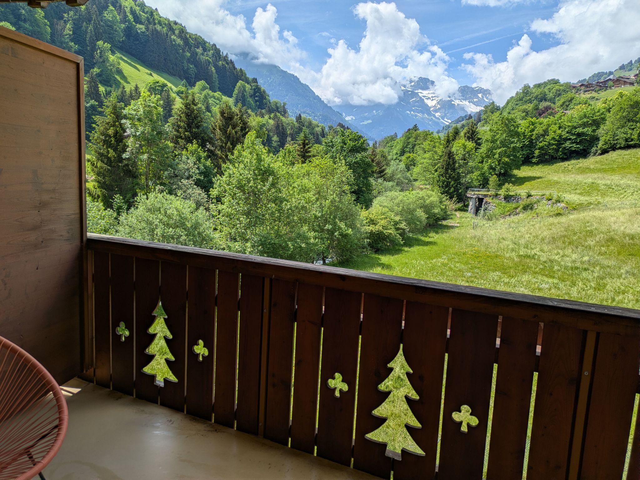 Ein Balkon mit Blick auf ein grünes Tal und Berge.