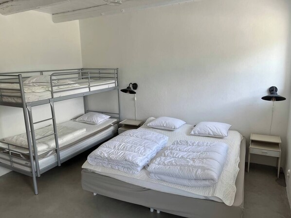 A bunk bed room with two bedside tables, each with a lamp.