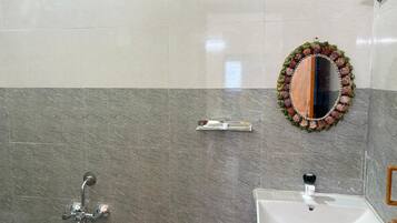 Un baño con ducha, lavabo y espejo.