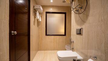 Un baño moderno con puerta de madera, inodoro, ducha y un perchero para toallas.