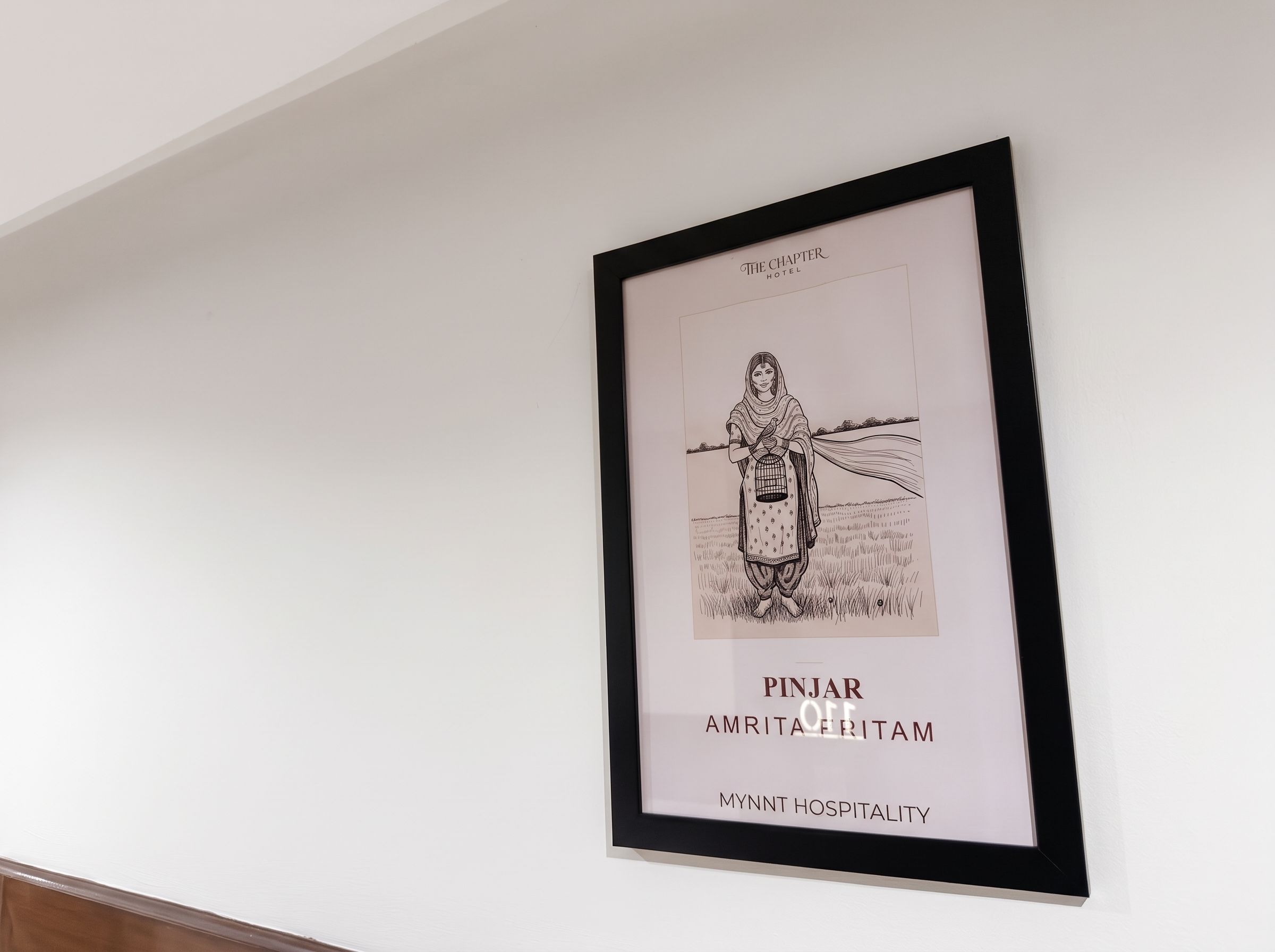 Obra de arte emoldurada retratando uma figura com uma gaiola de pássaros, intitulada 'PINJAR AMRITA FRITAM' pela MYNNT HOSPITALITY.