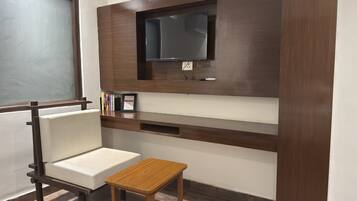 Una habitació amb escriptori, cadira i taula petita.