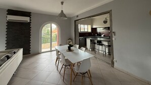 A modern kitchen with a dining area, a large window, and a view of the outdoors. - 4-Bedroom Apartment, 130 m², for Rehabilitation/Vacation Use (Balaruc-le-Vieux)
