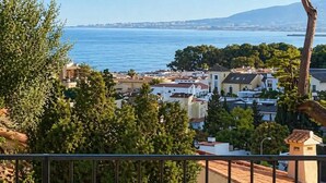 Uma cidade costeira com edifícios, árvores e vista para o mar.