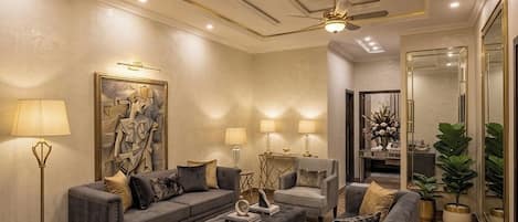 A modern living room with a sectional sofa, armchairs, a coffee table, and a chandelier.