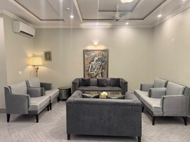 Una sala de estar con un sofá gris, una mesa de centro y un cuadro en la pared.