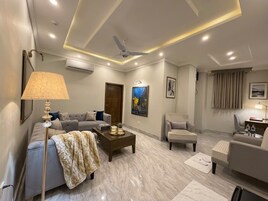 Una sala de estar moderna con sofá, sillón, mesa de centro y ventilador de techo.