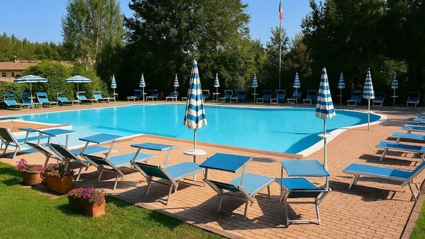 A swimming pool with lounge chairs and umbrellas, surrounded by trees. - Chalet in Maremma with Private Pool and Wi-Fi, Apt 23 (Castel del Piano)