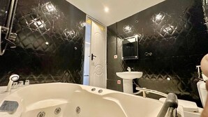 A bathroom with a large bathtub, a sink, and a mirror. - Blevama Homes (Dar es Salaam)