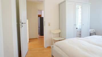 Ein Schlafzimmer mit einem Bett, einem Kleiderschrank und einem Sessel.