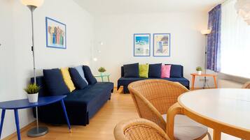 Ein modernes Wohnzimmer mit einer Couch, einem runden Tisch und einer Stehlampe.