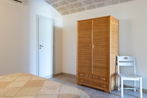 Quarto com um guarda-roupa grande, uma cadeira e uma porta.