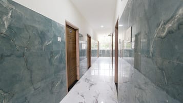 Un pasillo con paredes de mármol y una puerta de madera.
