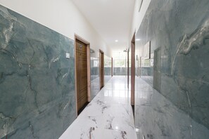 Un pasillo con paredes de mármol y una puerta de madera.