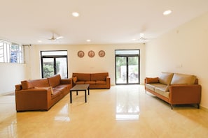 A spacious living room with two sofas, a coffee table, and a ceiling fan.