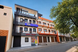A multi-story hotel with a reception area, balconies, and a sign for 'Mohini Palace'.