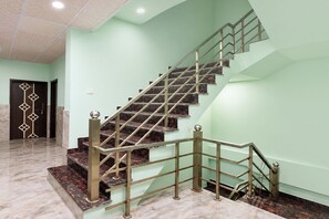 A staircase with a metal railing and marble steps.