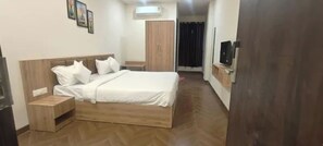 Un dormitorio con cama de madera, mesita de noche, armario y televisor.