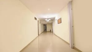 A long, narrow hallway with a flat ceiling and light-colored walls. - Via Lazeeno (Faridabad)