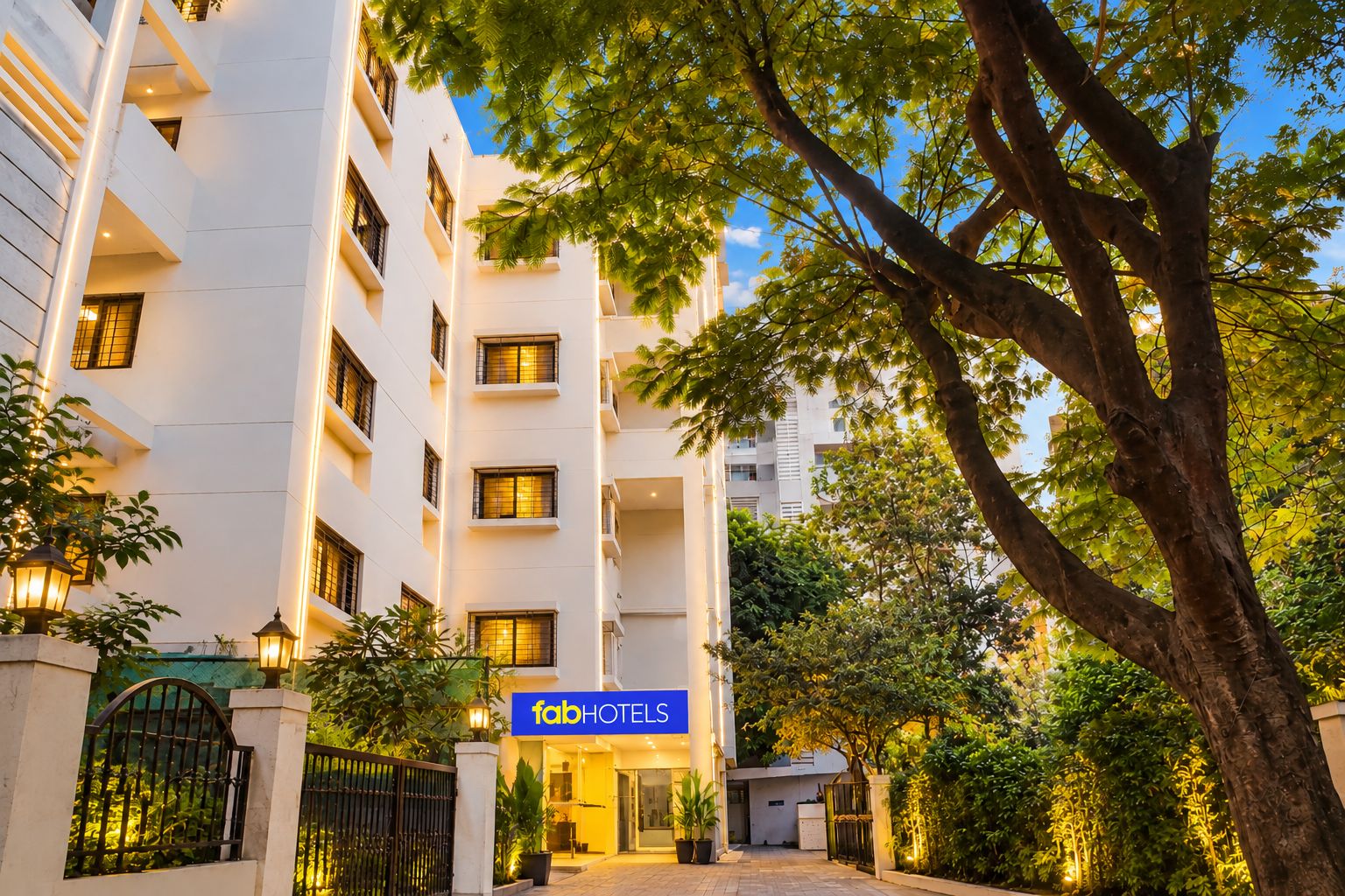 Un edificio de hotel de varios pisos con un letrero que dice 'fabHOTELS' en la entrada.