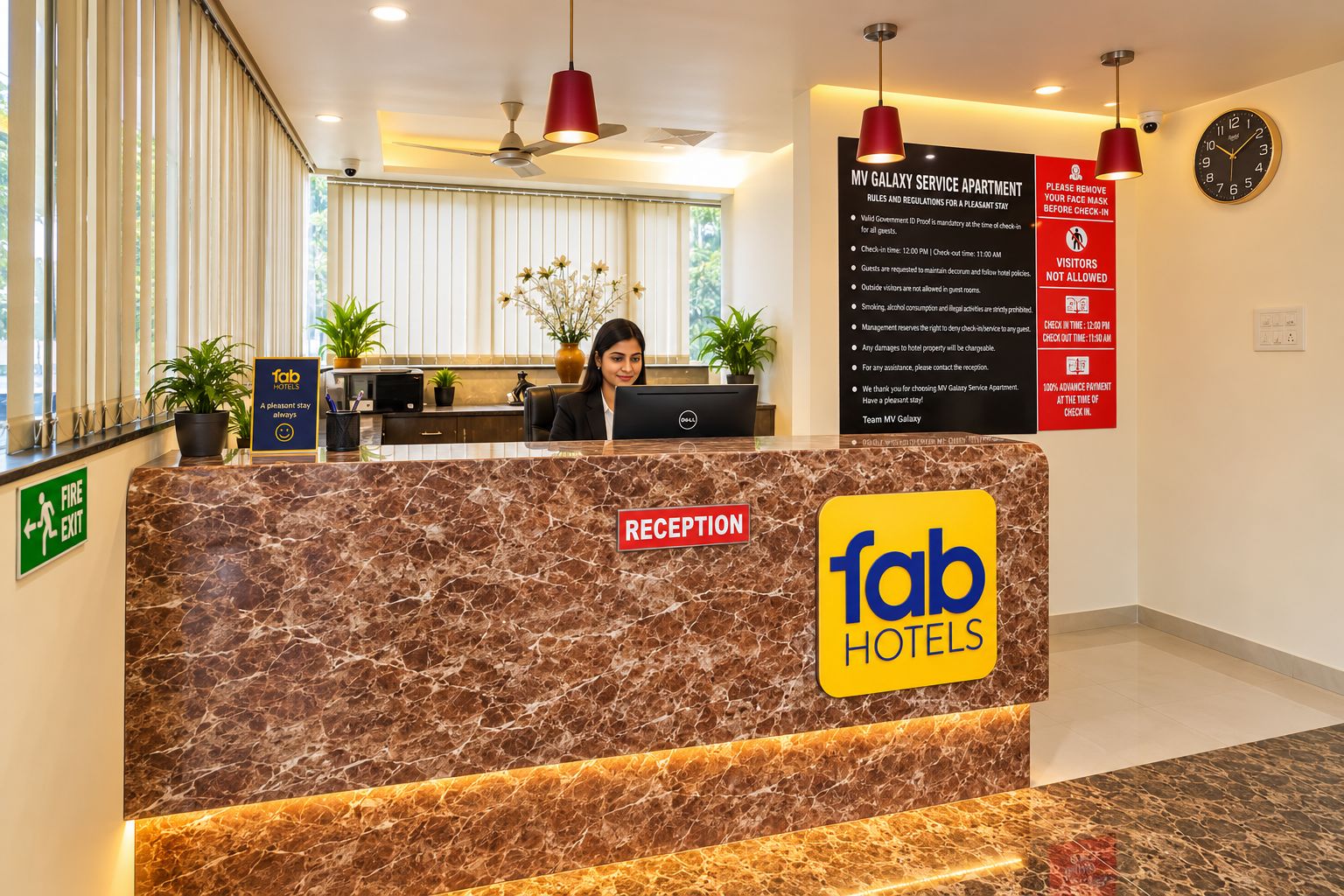 A reception desk at Fab Hotels with a marble counter, a reception sign, and a sign detailing MV Galaxy Service Apartment rules.