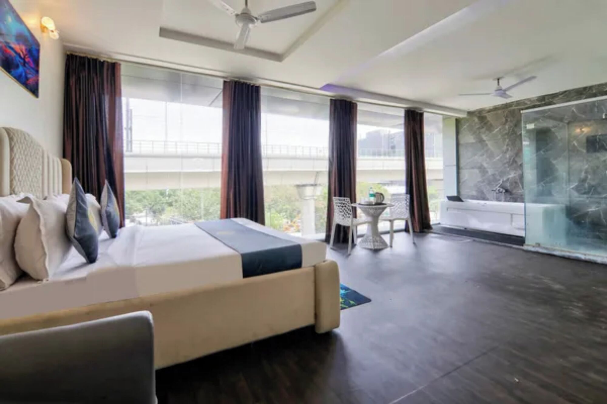 Une chambre d’hôtel avec un lit, un balcon, un coin salon et une vue sur l’extérieur.
